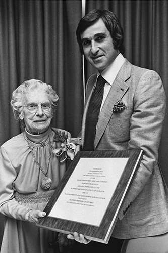 Elizabeth Bagshaw stands next to a man holding a framed certificate