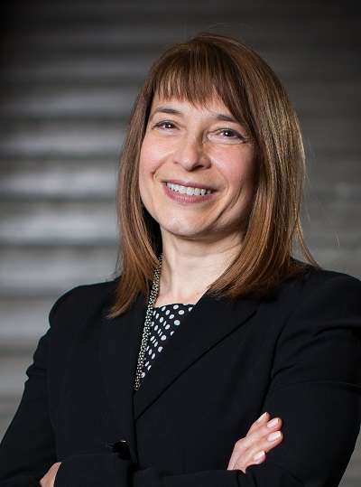 Photo of Barbara Dick with arms crossed and smiling