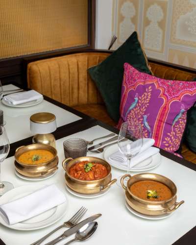 A table at Adrak Yorkville restaurant, featuring various dishes of Indian food.
