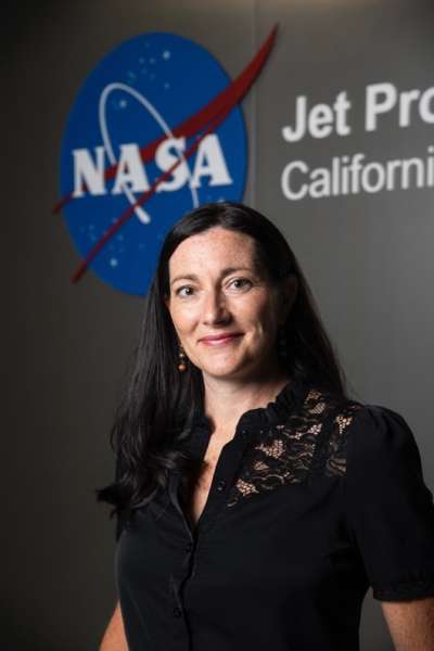 Carrie standing in front of the NASA logo
