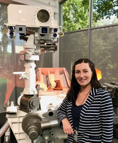 Carrie in a laboratory standing in front of a machine