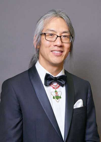 Portrait of Tom Chau smiling and wearing the Order of Ontario medal.