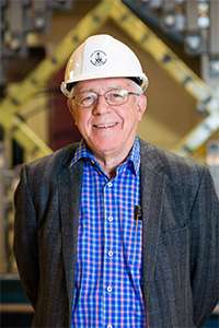 Michael Patrick Collins smiling and wearing a hard hat.