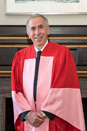 Alan Bernstein smiling and wearing academic robes.