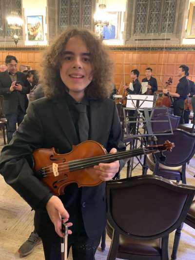 Daniel Honciuc Menendez holding a violin at Hart House