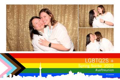 Jackie Nguyen and Ivana Van-Tol try out different poses in a photo booth decorated with the rainbow flag.