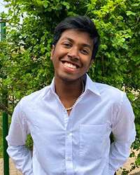 Benjamin Koshy Jacob smiles, standing in a garden.