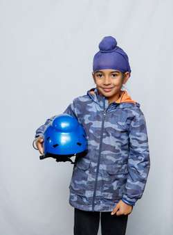 A kid carrying his helmet under his arm