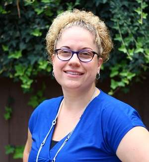 Portrait photo of Kristen Moore, outdoors and smiling