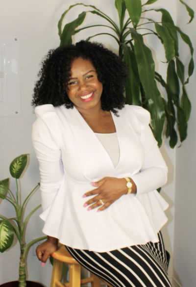 Melisa Ellis: a young Black woman laughing and sitting on a stool by a plant.