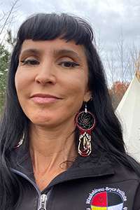 Portrait of Suzanne Stewart smiling, outdoors.