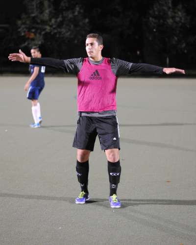 Yahya Ali playing soccer on a field at night.