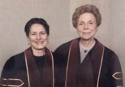 Natalie Davis and Jill Conway smile, posing side by side in academic robes.