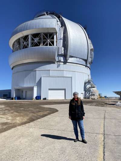 Emily standing by a giant telescope