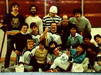 In a photo from the 1980s, a broomball team poses for a picture on the ice.