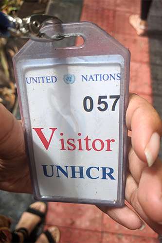 A close-up of a United Nations UNHCR visitor badge.