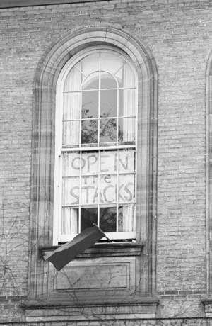 An arched window with a protest sign