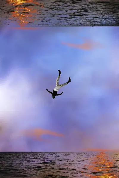 A person falling from the sky above a body of water