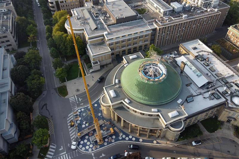 A tall crane stands next to Convocation Hall and its circular roof with a skylight in the centre.