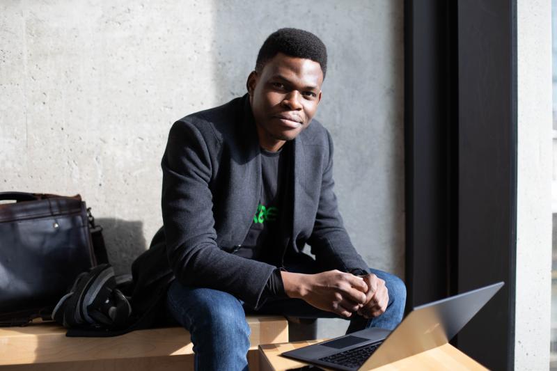 Olugbenga Olubanjo smiles as he looks up from the laptop he is working on.