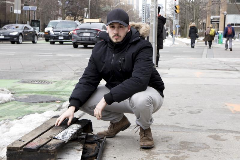 Graduate student David Wosnick, next to the remains of a hotdog cart that was destroyed in a fire Sunday night.