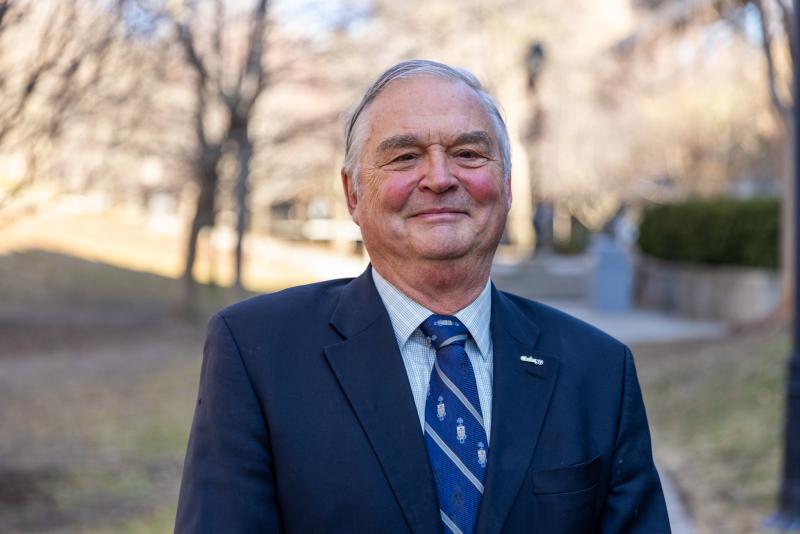A portrait of a person wearing a blue business suit and tie.
