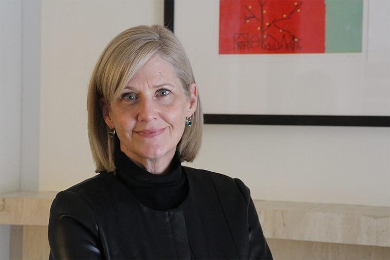 Barbara Fallon smiling in front of an abstract artwork.