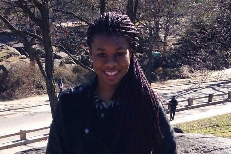 Chelsea Chioma Anthony smiling. She is standing in a park overlooking a road.