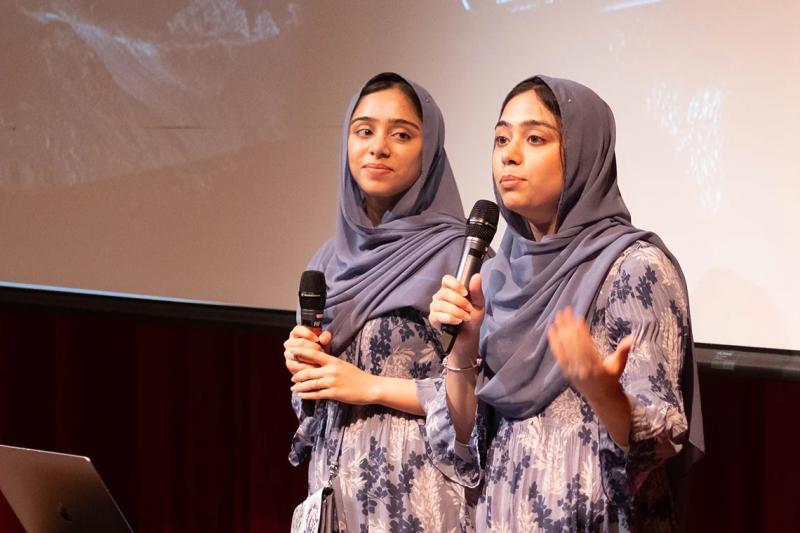 Nivaal and Maryam Rehman stand on stage, holding microphones