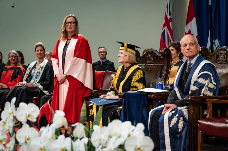 Sarah Polley on stage in a gown receiving her degree
