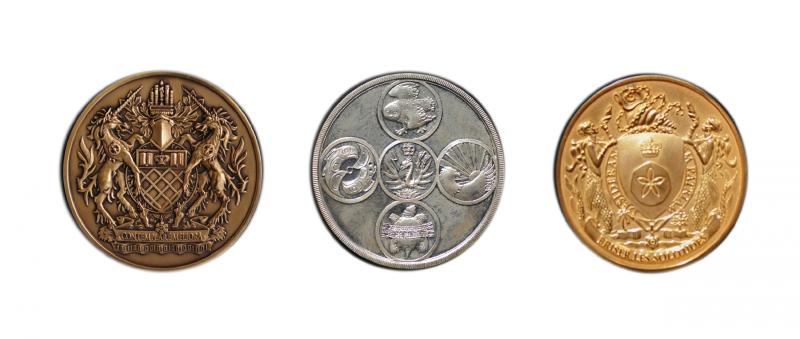An image of the Governor General's medals. The gold shows a shield held up by mermaids and the motto: Briser les solitudes.