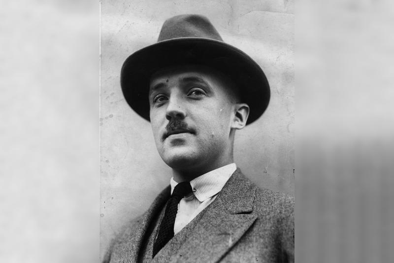 Portrait of Charles Best looking serious in a hat outdoors.