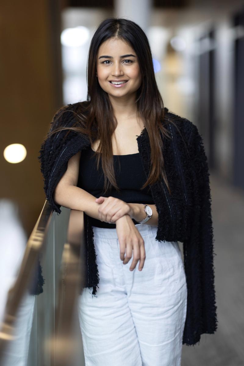 A portrait of Athiya Rastogi wearing a black top and white pants