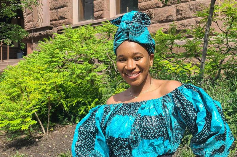 Matida Daffeh smiling and standing in a garden.