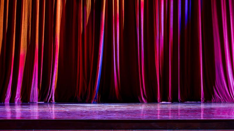 A red curtain pulled across a theatre stage