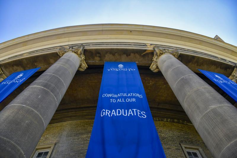 A banner reading Congratulations to our graduates hangs between the pillars outside Convocation Hall.