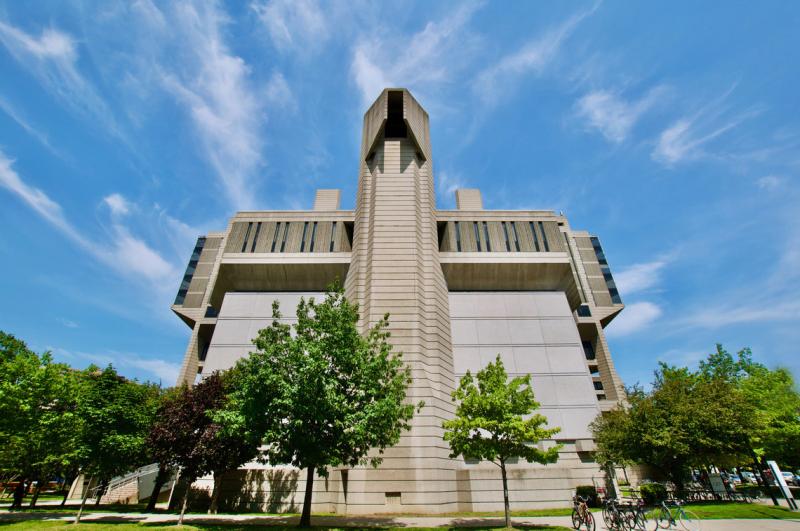 The concrete facade of the Robarts Library soars up against a sunny sky.