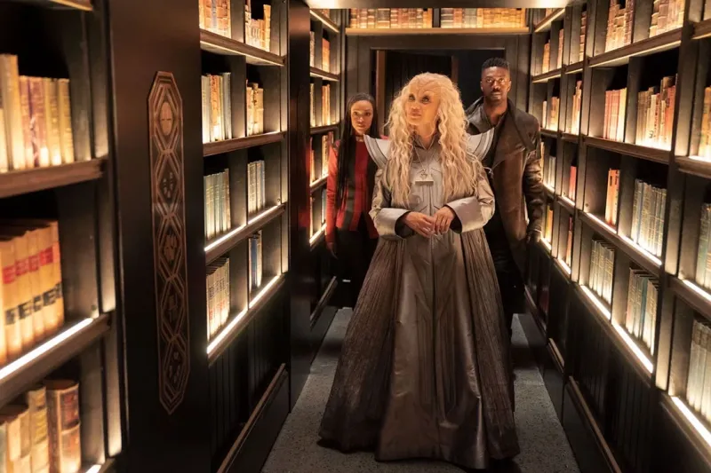 Three Star Trek characters standing in library stacks
