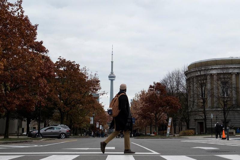 Student crossing Convocation Plaza in front of the CN Tower. Photo by Laura Pederse