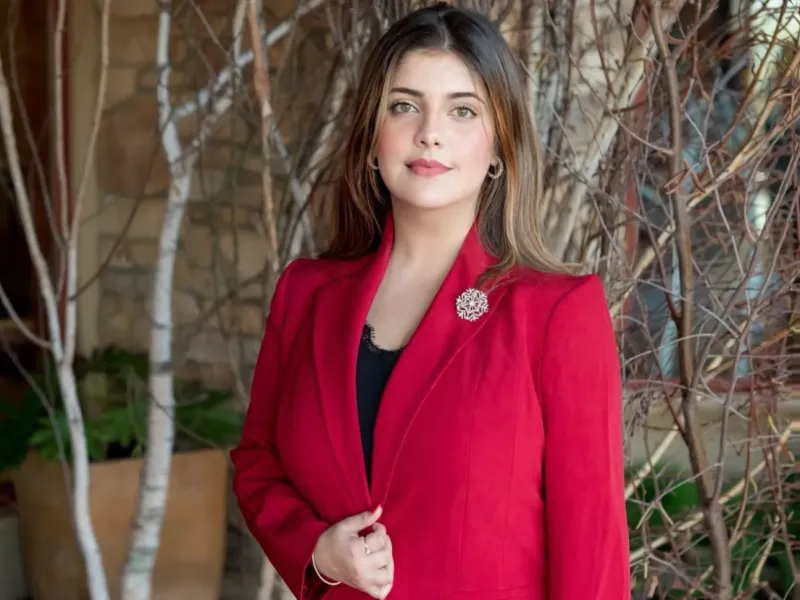 A portrait of a woman wearing a red blazer