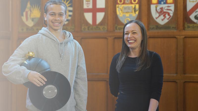 Danielle Dinunzio stands next to a male student in Hart House, both smiling.