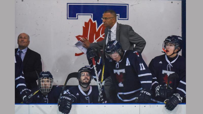 Darren Lowe and several hockey players on the bench
