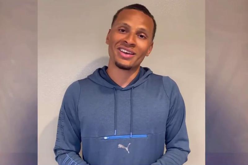 Andre De Grasse smiling and talking on a video call.
