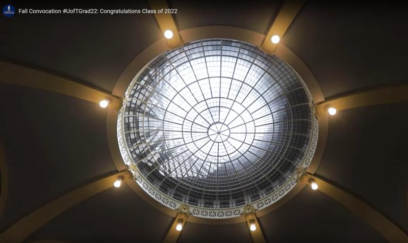Lights shine like stars around the bright oculus window in the ceiling of Convocation Hall.