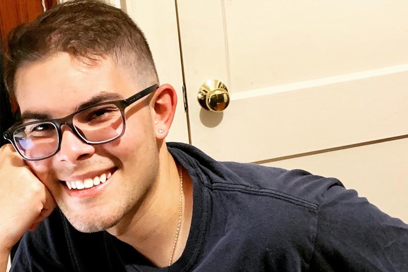 Lucas Aragao smiling and leaning his face on one hand.