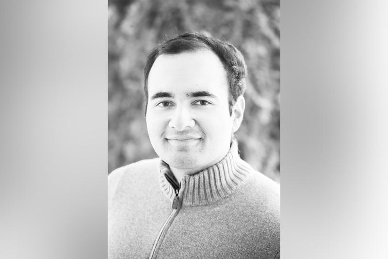 A black and white portrait of Mohammad Asadi-Lari smiling.