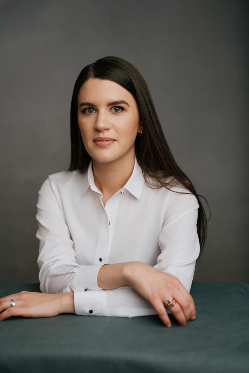 A portrait of a person in a white dress shirt