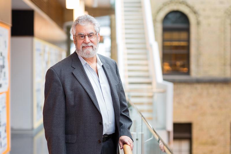 Michael Sefton stands in an indoor atrium that combines modern and heritage architecture.