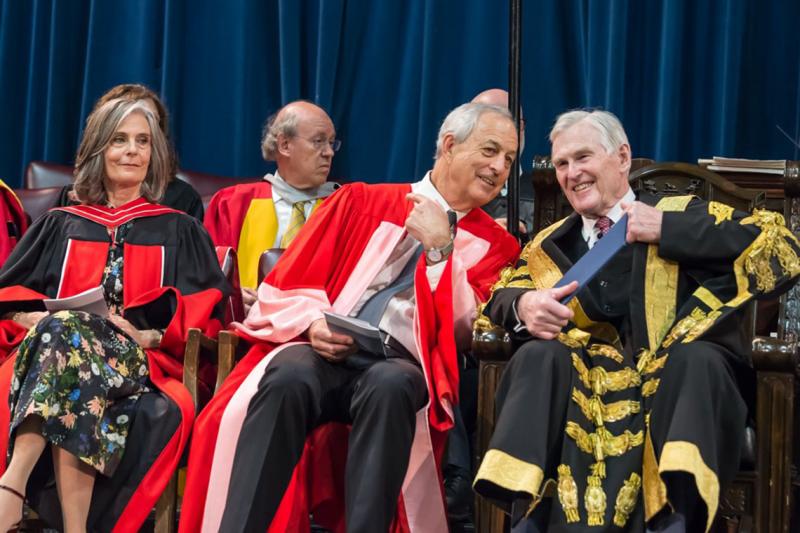 Geoffrey Matus, who received an honorary doctor of laws, honoris causa, on Wednesday, speaks to U of T Chancellor Michael Wilson at the convocation ceremony (photo by Steve Frost)
