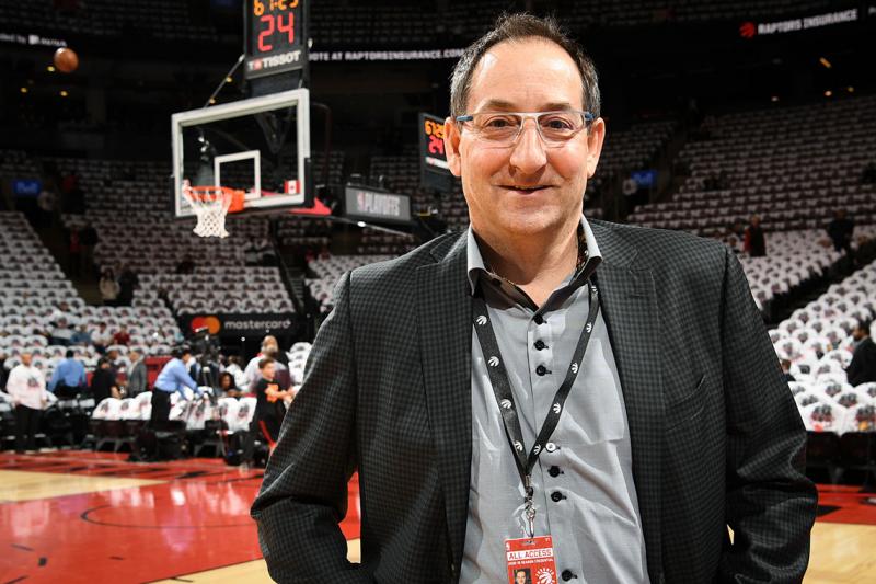 Dr. Howard Petroff smiles as he stands by the edge of the Raptors' basketball court.